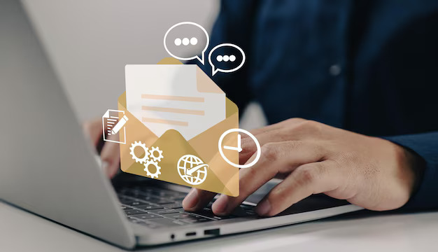 A close-up of hands typing on a laptop, overlaid with icons of an envelope, chat bubbles, gears, and clock. Represents communication and technology.